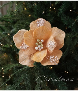 Gedetailleerde weergave van champagne goud kerstbloem met parels op een kerstboomtak