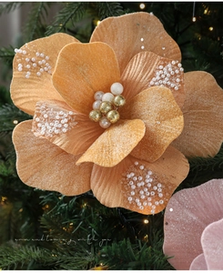 Detailopname van oranje fluwelen kerstbloem met parels en glitters in de kerstboom