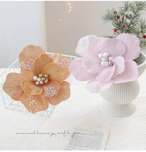 Detail van stoffen kerstbloemen met glitterblaadjes en parelcentra in vazen