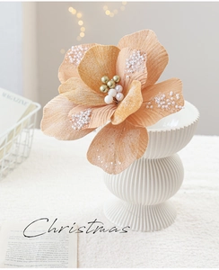 Abrikoosroze kunstkerstbloem met parels in een witte keramische vaas voor decoratie