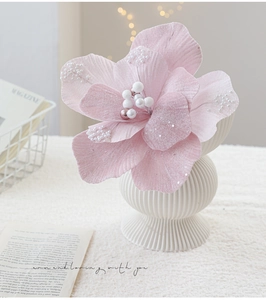 Roze fluwelen kunstbloem met parels en glitters in een witte geribbelde keramiek vaas
