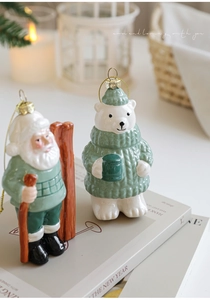 Detail view of ceramic Santa and polar bear ornaments on a cozy holiday tabletop setting