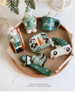 Detail of mint green and cream white ceramic Christmas tree ornaments in a woven tray