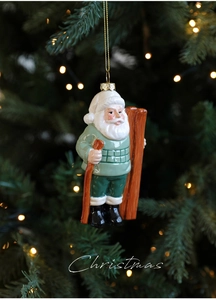 Detail of Santa Claus ornament with skis on a Christmas tree with festive lights