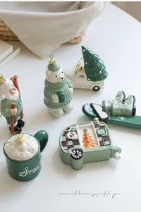 Detail view of 6-piece ceramic Christmas ornaments in Nordic green and cream white colors