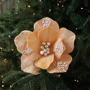 Champagnegouden stoffen kerstbloem met witte parels en kralen op dennenaaldtakken