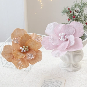Glinsterende fluwelen kerstbloemen in oranje en roze met parels voor feestelijke decoratie