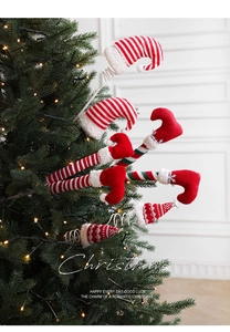 Détails de jambes et chapeaux d'elfe en peluche avec ressorts sur sapin de Noël illuminé