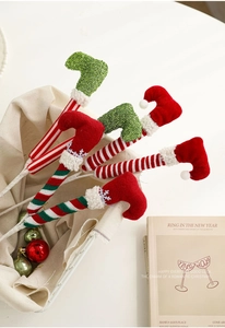 Vue détaillée des jambes de lutin de Noël rayées avec des bottes de fête en velours