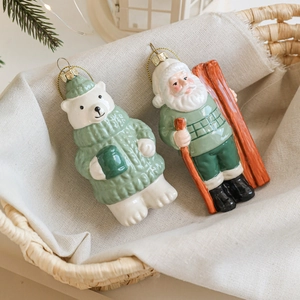 Christmas tree ornaments featuring a polar bear and Santa Claus in green knitted sweaters
