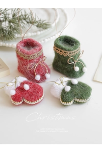 Detail of plush Christmas glove and boot ornaments with golden lace and white pom-poms
