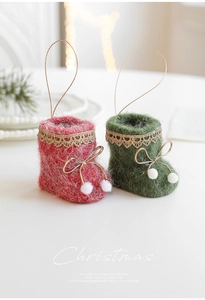 Detail of plush red and green felt Christmas boots ornaments with gold lace and white pom-poms