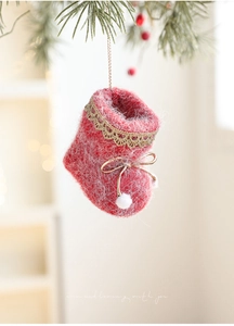 Detail of red knit Christmas boot ornament with gold lace trim and white pom-pom decor