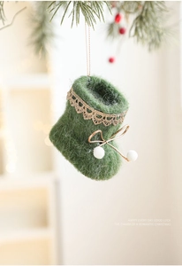 Detail view of green felt Christmas boot ornament with gold lace and white pom-poms