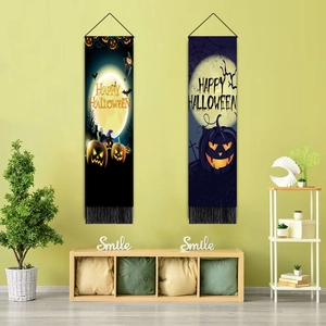 Dettaglio di striscioni di Halloween con motivi a zucca e nappe nere sulla parete verde