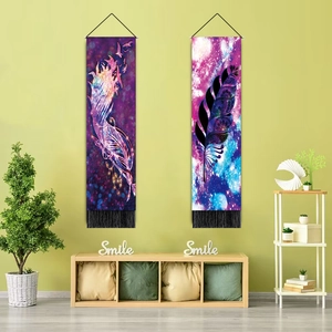 Detail of colorful feather tapestry with tassels hanging on a wall in a cozy room