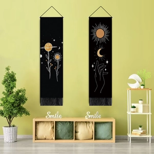 Close-up of dual Nordic tapestries with gold accents and black tassels on a green wall