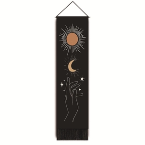 Detail of bohemian tapestry with sun, moon, and hand line art including tassel trim