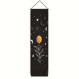 Detail of black bohemian tapestry featuring a golden sun, celestial patterns and bottom fringe
