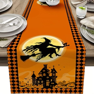 Detail of Halloween table runner with witch and pumpkin prints on dark wood table