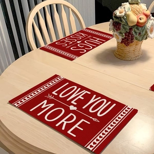 Détail macro de sets de table en lin rouge pour la Saint-Valentin avec texte blanc