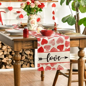 Detail of linen table runner with red watercolor hearts and cursive love print