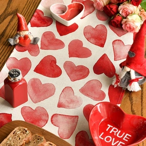 Linen table runner with red watercolor hearts on dark wood table for Valentine's Day decor
