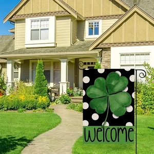Outdoor setup of clover garden flag with Welcome text on black polka dot linen