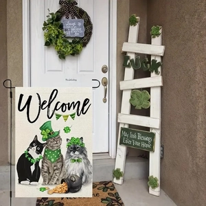 Detail of St. Patrick's Day garden flag with cute cats and clover on linen fabric