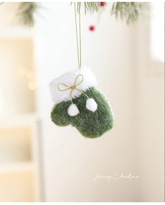 Detail of green felt Christmas glove ornament with white faux fur trim and gold bow