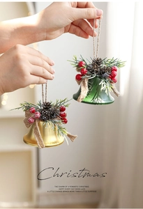 Close-up of Christmas bells with pine cones, red berries and a rustic burlap bow decor