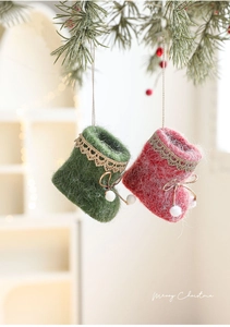 Close-up of felt Christmas boot ornaments with gold lace and white pom-poms on a tree