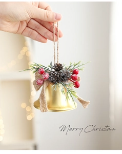 Detail of gold Christmas bell with pine cones, red berries and a burlap bow on jute rope