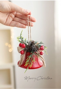 Close-up of red metal Christmas bell with pine cones, red berries and Merry Christmas text