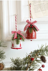 Close-up of red and white metal Christmas bells with checkered bows and pine accents
