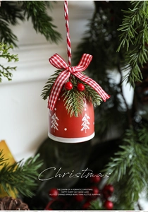 Detailed view of red Christmas bell with white tree patterns and checkered ribbon bow