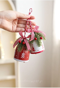Close-up of red and white Christmas bells with plaid bows, berries, and pine needles