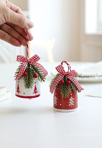 Close-up of metal Christmas bells with festive red berries and checkered bows ornaments