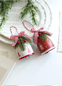 Close-up of red and white Christmas bells with bows, pine needles and berries