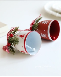 Detail of Christmas metal bells with red plaid bows and artificial pine needles