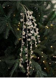 Golden Christmas tree branch with white pearls and clear crystals on green pine