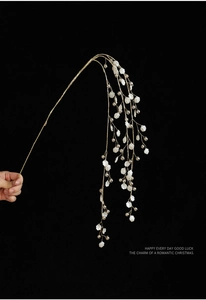 Detail of beaded Christmas branch with white shell-like leaves and gold wire beads