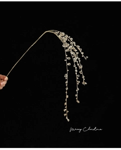 Close-up of golden Christmas branches with clear acrylic teardrop crystal ornaments