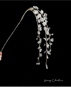 Macro detail of Christmas floral branch with white petals and gold wire on black background