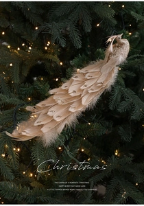 Dettaglio di un pavone decorativo in piume color champagne con glitter dorati su albero di Natale