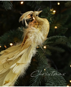 Dettaglio di un uccello di Natale dorato con piume e paillettes su un ramo di pino verde