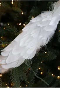 Dettaglio di uccello decorativo con piume bianche e glitter viola su ramo di Natale