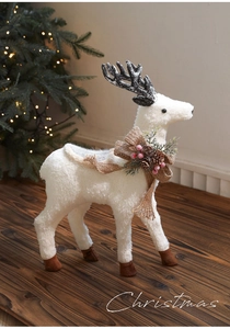 Close-up of white foam reindeer with burlap bow and festive berries for Christmas decor
