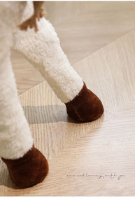 Close-up of plush white foam reindeer legs with brown hooves on wooden floor decor