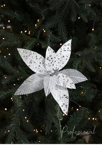 Close-up of a silver artificial poinsettia with sequins on a decorated Christmas tree
